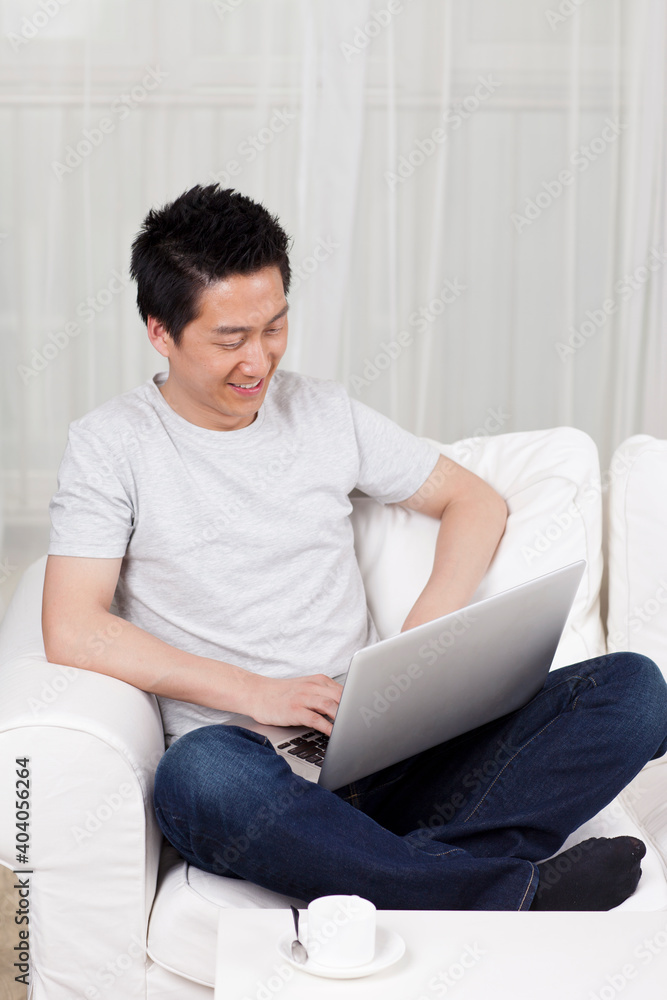 Cheerful businessman using a laptop computer in sofa Cheerful businessman using a laptop computer in sofa