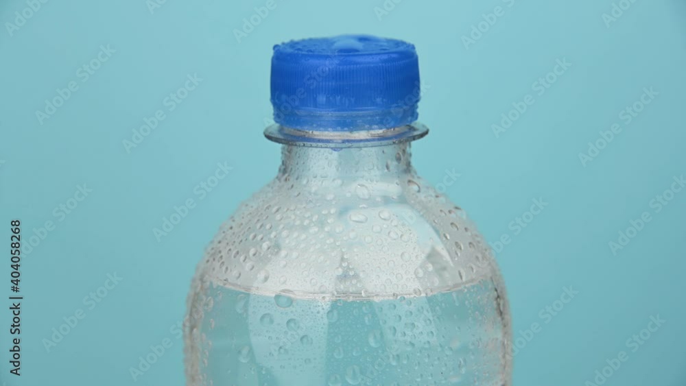 Plastic bottle of water rotating over blue Plastic bottle of water rotating over blue