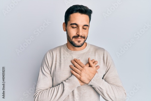 Young hispanic man wearing casual clothes smiling with hands on chest, eyes closed with grateful gesture on face. health concept.