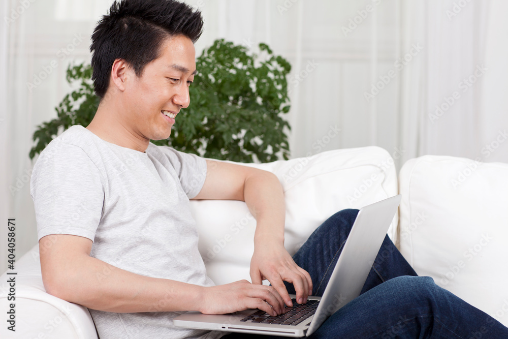 Cheerful businessman using a laptop computer in sofa Cheerful businessman using a laptop computer in sofa