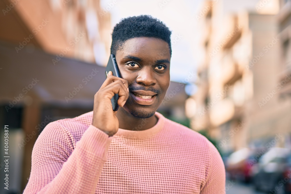 Young african american man smiling happy talking on the smartphone at the city. Young african american man smiling happy talking on the smartphone at the city.