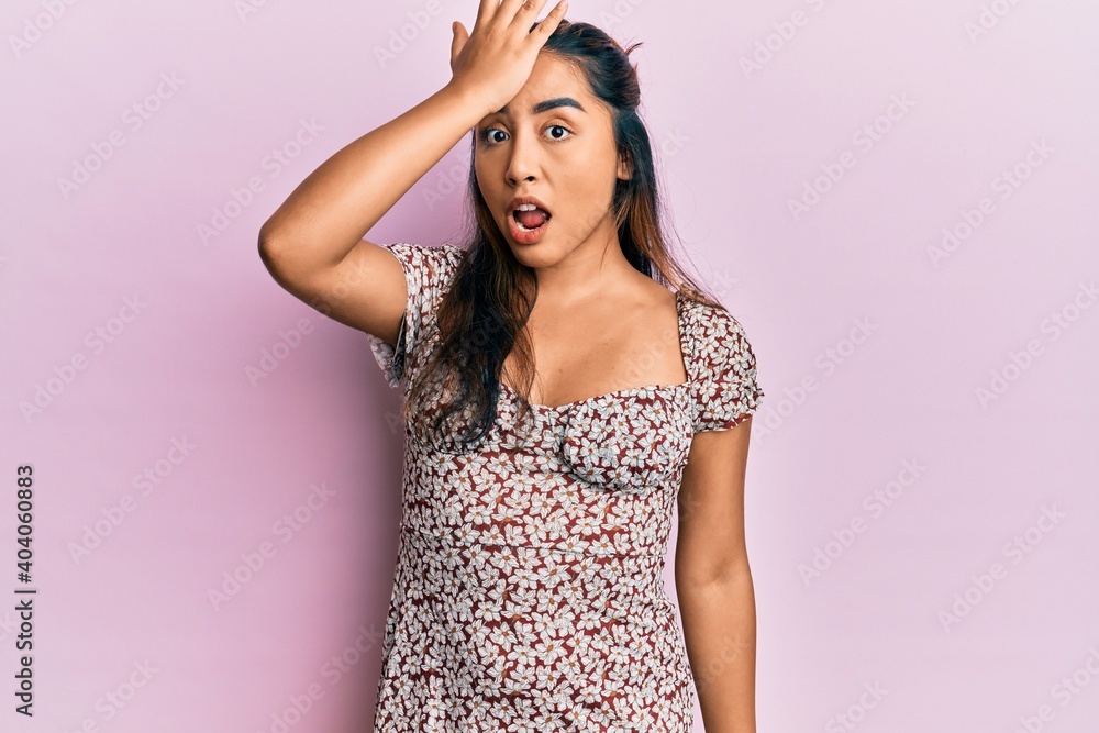 Young latin woman wearing casual clothes surprised with hand on head for mistake, remember error. forgot, bad memory concept. Young latin woman wearing casual clothes surprised with hand on head for mistake, remember error. forgot, bad memory concept.