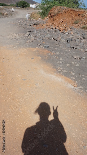 the shadow of a hiker doing a V sign in Caihau, on the island Sao Vicente, Cabo Verde, in the month of November