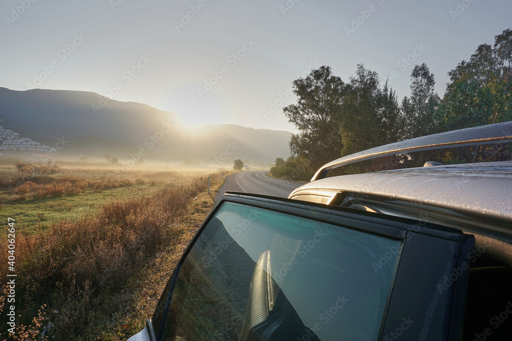 Rear part of the car at sunrise on an empty road