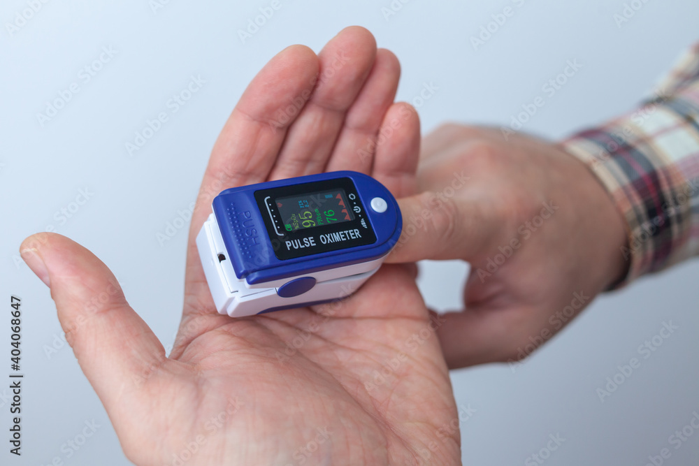 The man checks his oxygen level. Oximeter The man checks his oxygen level. Oximeter