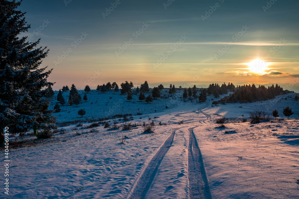 Winter sunset over dirtroad on the top of the mountain in the Carpathian mountains.