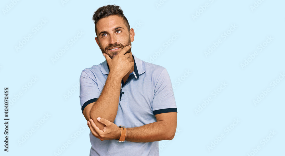 Handsome man with beard wearing casual clothes with hand on chin thinking about question, pensive expression. smiling and thoughtful face. doubt concept. Handsome man with beard wearing casual clothes with hand on chin thinking about question, pensive expression. smiling and thoughtful face. doubt concept.