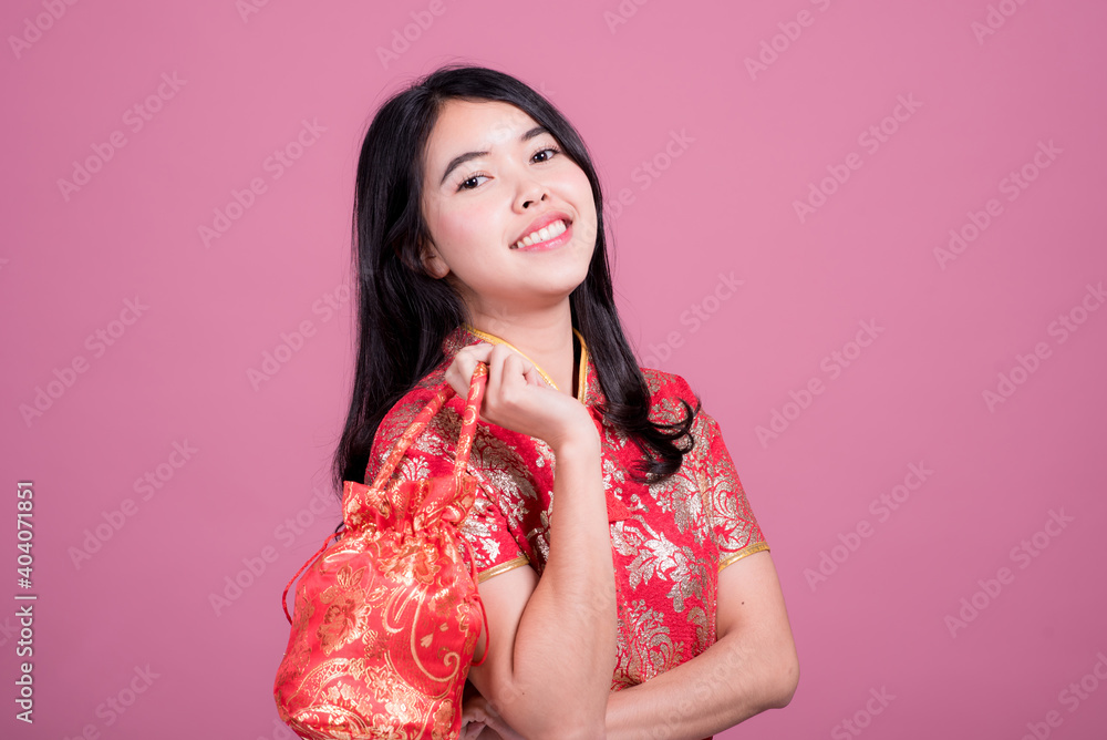 Action portrait beautiful Asian girl wearing Cheongsam red dress. the celebration of something in a joyful and exuberant way. Festivities and Celebration concept Action portrait beautiful Asian girl wearing Cheongsam red dress. the celebration of something in a joyful and exuberant way. Festivities and Celebration concept