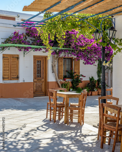 Traditional Cycladitic alley with traditional houses and a blooming bougainvillea flowers in lefkes Paros island, Greece © valantis minogiannis