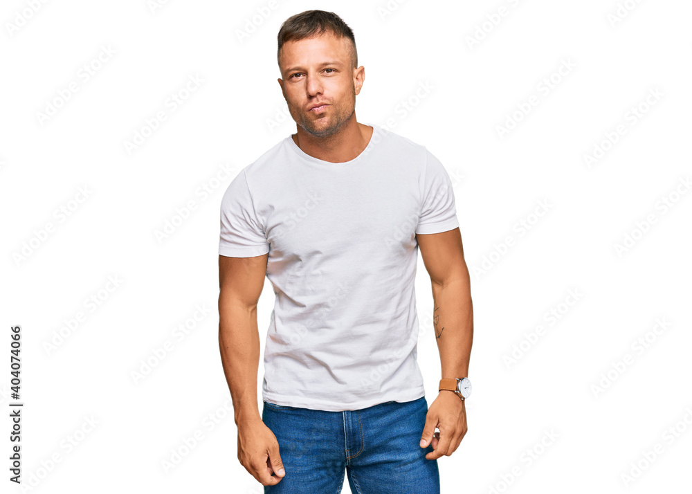 Handsome muscle man wearing casual white tshirt looking at the camera blowing a kiss on air being lovely and sexy. love expression. Handsome muscle man wearing casual white tshirt looking at the camera blowing a kiss on air being lovely and sexy. love expression.