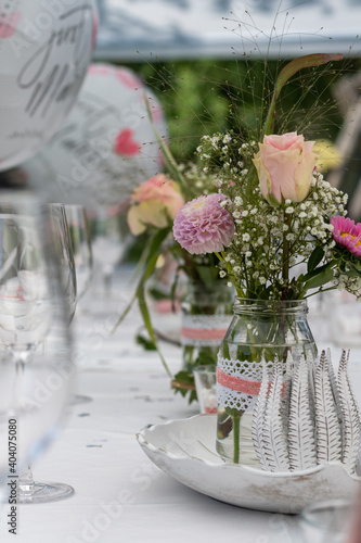 Hochzeitstafel mit Tischdeko bestehend aus Luftballons, Blumen und Gläsern