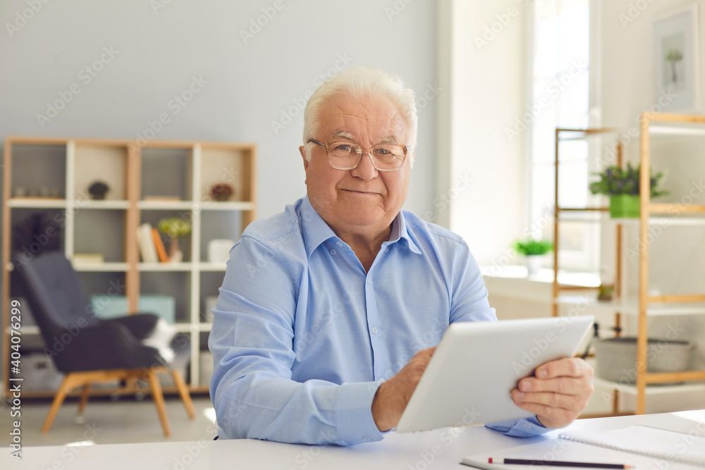 Happy senior man shopping online, managing budget and reading news using tablet. Happy senior man shopping online, managing budget and reading news using tablet.