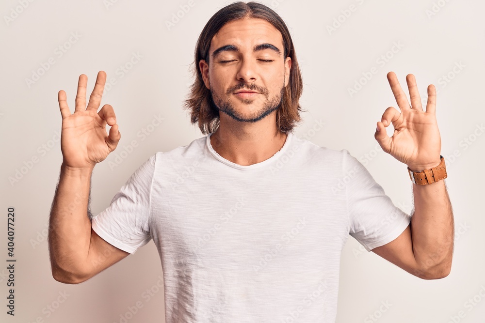 Young handsome man wearing casual clothes relax and smiling with eyes closed doing meditation gesture with fingers. yoga concept. Young handsome man wearing casual clothes relax and smiling with eyes closed doing meditation gesture with fingers. yoga concept.