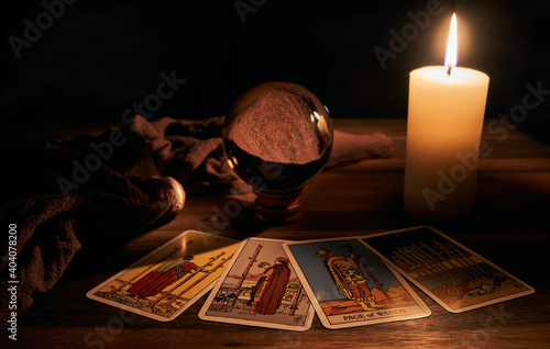 Photo concept of fortune-telling wooden table and white candle with a crystal ball and