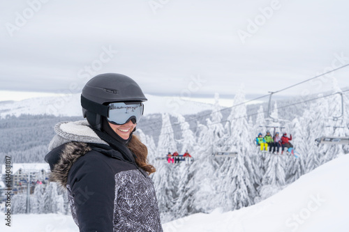 Foto A woman with a nice smile and ski equipment poses on a ski slope near the cable