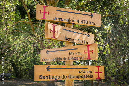 Camino Lebaniego Castellano, wooden signpost pointing several directions to sacred places: Jerusalen, Roma, Santo Toribio, Santiago de Compostela photo