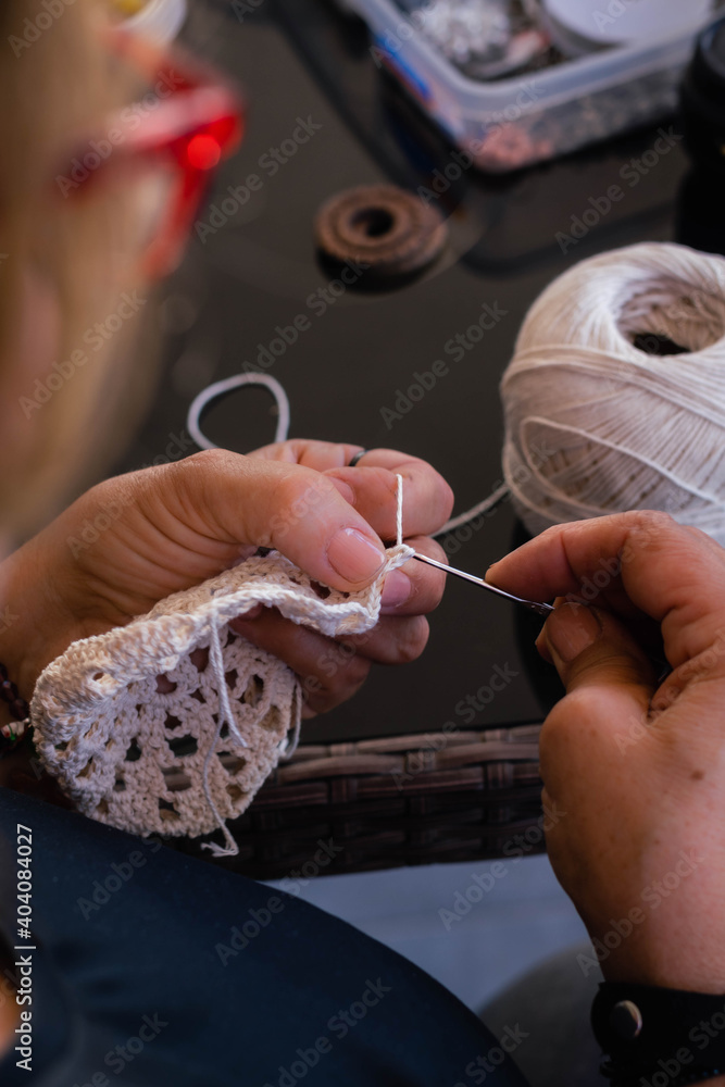 hand of person making handicrafts of wool and thread weaves dreamcatcher with needle and ball córdoba argentina
