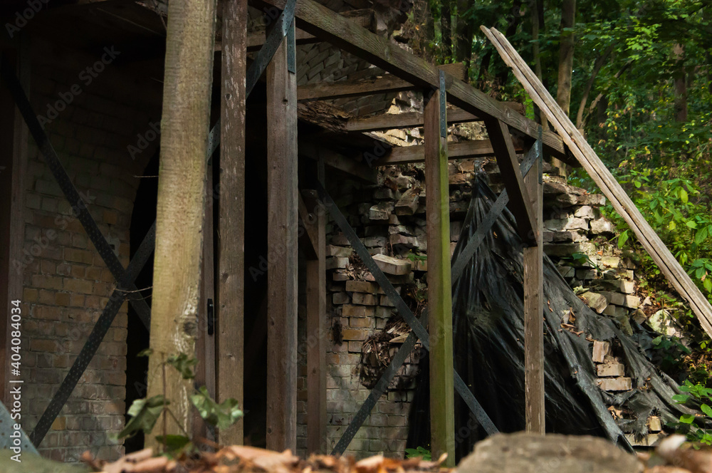 Verlassenes gemauertes Gebäude mit Gestell aus Holzbohlen. Kurz vor dem Einsturz