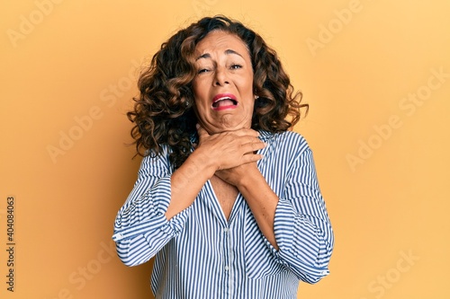 Middle age hispanic woman wearing casual clothes shouting and suffocate because painful strangle. health problem. asphyxiate and suicide concept.