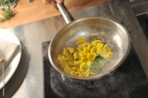 Ravioli del plin, typical pasta of the Langhe, Piedmont, Italy - agnolotti creamed in a pan with butter and sage photo