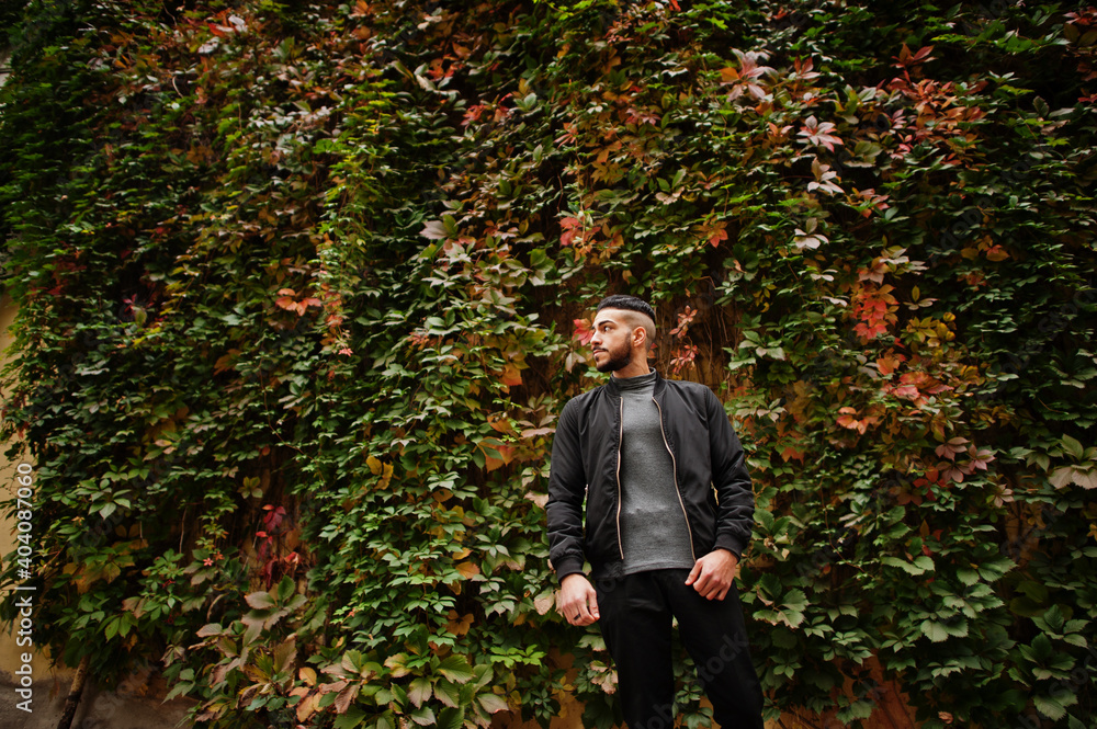 Portrait of stylish arab beard man wear grey turtleneck and black jaket. Arabian model guy on a background of autumn leaves. Portrait of stylish arab beard man wear grey turtleneck and black jaket. Arabian model guy on a background of autumn leaves.