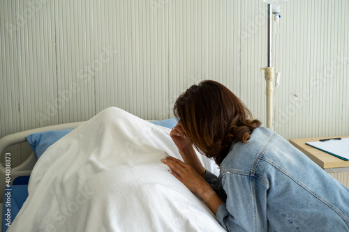 Asian woman daughter crying mourning on death patient on hospital bed 