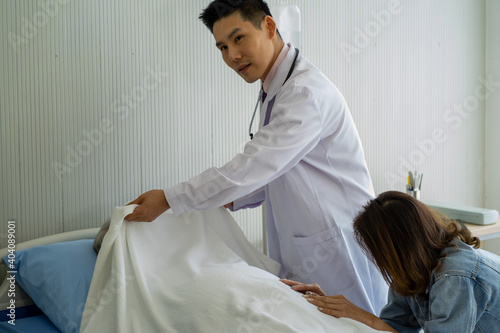 Asian medical doctor wearing white gown stethoscope standing with death patient on hospital bed 