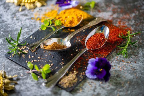 A black board with colourful spices arranged for cooking. Copy Space.