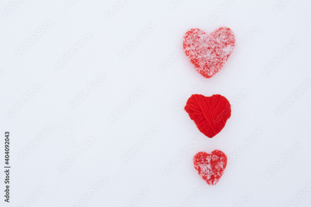 Valentines Day background with hearts. A pair of vintage decorative heart sticking out of the snow surface.