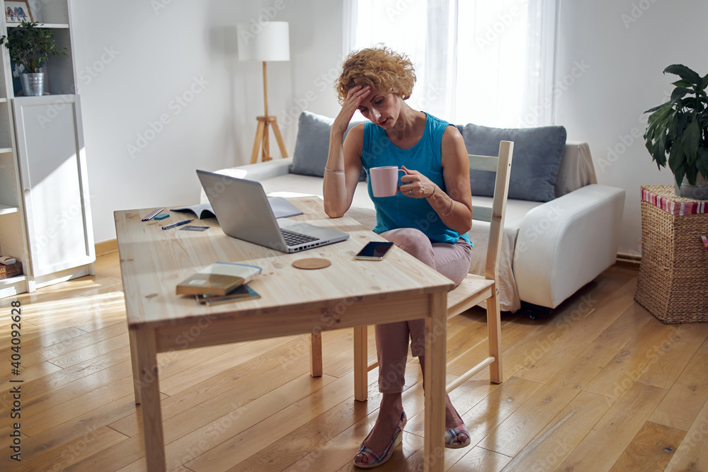 Woman working from home and being depressed, tired with headache. Modern concept and problems with freelancers. Woman working from home and being depressed, tired with headache. Modern concept and problems with freelancers.