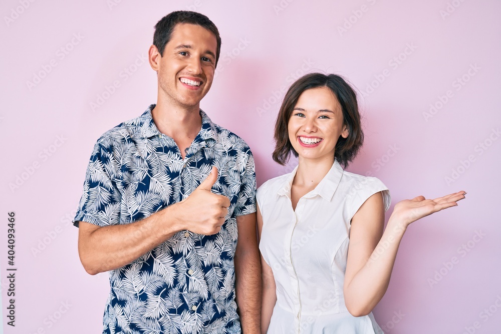 Beautiful couple wearing casual clothes showing palm hand and doing ok gesture with thumbs up, smiling happy and cheerful Beautiful couple wearing casual clothes showing palm hand and doing ok gesture with thumbs up, smiling happy and cheerful