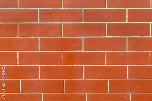 Texture wall with red, polished facing tile in the form bricks