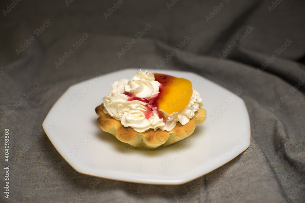 tartlets made of dough with cream and fruit on a white plate tartlets made of dough with cream and fruit on a white plate