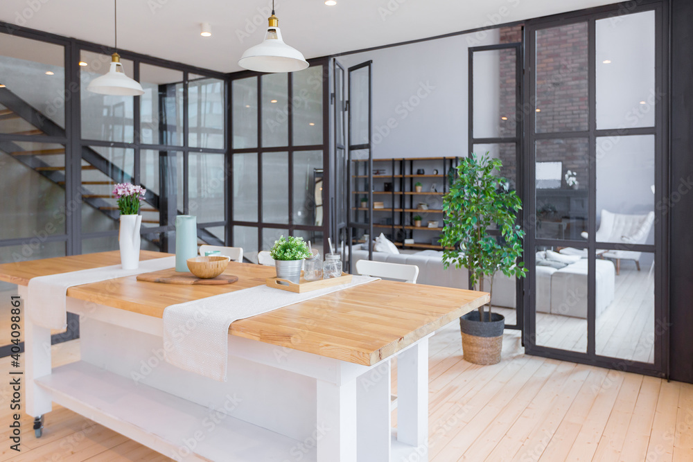 trendy modern design two-level apartment with large high windows. The stylish living room and kitchen in bright colors are undressed by a glass partition. bedroom on the second floor. trendy modern design two-level apartment with large high windows. The stylish living room and kitchen in bright colors are undressed by a glass partition. bedroom on the second floor.