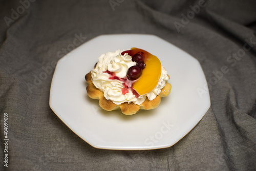 tartlets made of dough with cream and fruit on a white plate