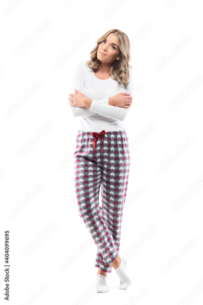Delicate cute young woman in cozy pajama sleepwear with crossed hands looking at camera. Full body length isolated on white background. Delicate cute young woman in cozy pajama sleepwear with crossed hands looking at camera. Full body length isolated on white background.
