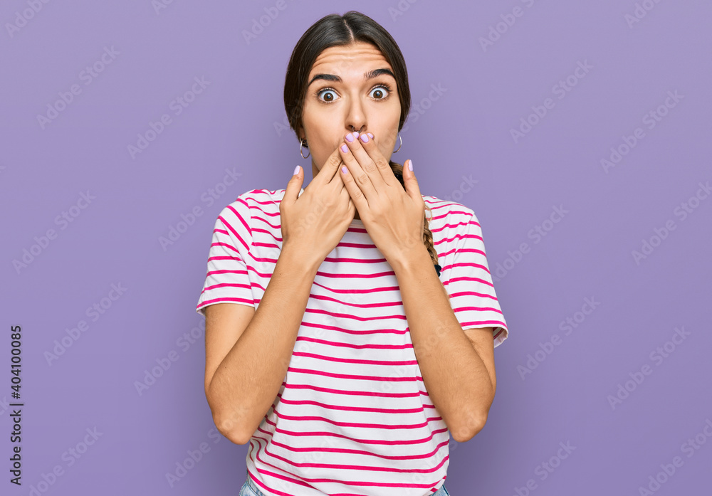 Young hispanic woman wearing casual clothes shocked covering mouth with hands for mistake. secret concept. Young hispanic woman wearing casual clothes shocked covering mouth with hands for mistake. secret concept.