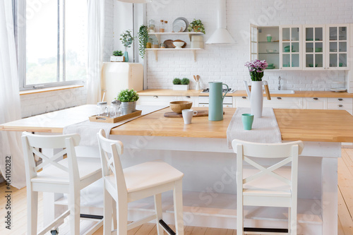 Stylish kitchen in light colors in a trendy modern duplex apartment with large high windows. © 4595886