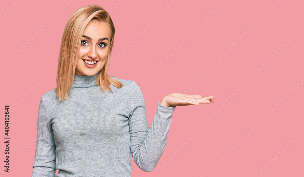 Beautiful caucasian woman wearing casual clothes smiling cheerful presenting and pointing with palm of hand looking at the camera. Beautiful caucasian woman wearing casual clothes smiling cheerful presenting and pointing with palm of hand looking at the camera.