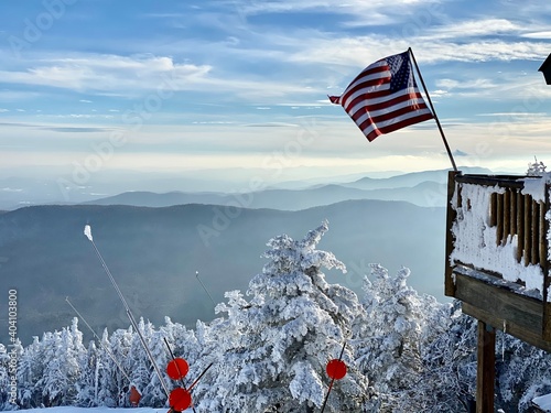 American flag waiving at the ski patrol house at the beautiful snow day at the Stowe Mountain Ski resort Vermont - December 2020