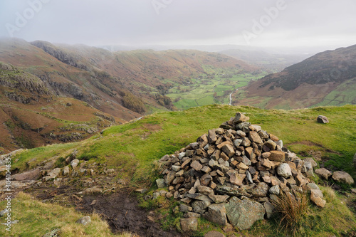 View over a large cairn down the valley of Great Langdale on the way up Loft Crag in the Langdale Pikes, Lake District, UK photo