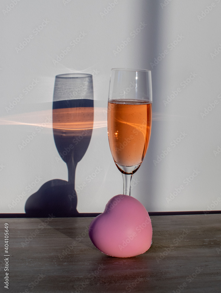 Obraz premium Jeden kieliszek z alkoholem z drugim kieliszkiem jako cień iluzja optyczna walentynki