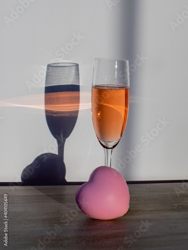 Jeden kieliszek z alkoholem z drugim kieliszkiem jako cień iluzja optyczna walentynki