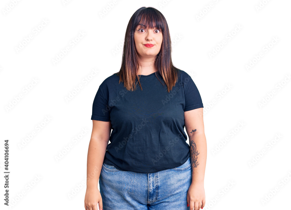 Young plus size woman wearing casual clothes puffing cheeks with funny face. mouth inflated with air, crazy expression. Young plus size woman wearing casual clothes puffing cheeks with funny face. mouth inflated with air, crazy expression.
