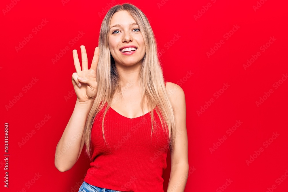 Young blonde woman wearing casual clothes showing and pointing up with fingers number three while smiling confident and happy. Young blonde woman wearing casual clothes showing and pointing up with fingers number three while smiling confident and happy.