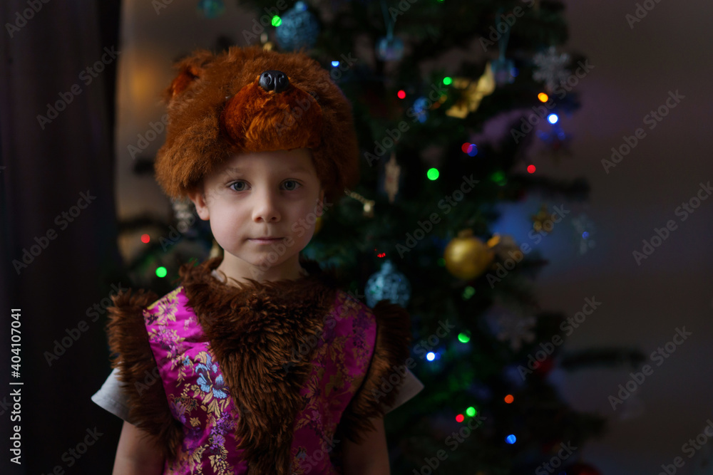 cute little boy in a bear costume standing near christmas tree cute little boy in a bear costume standing near christmas tree