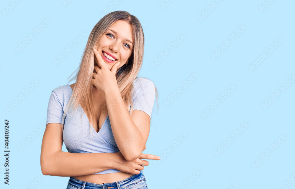 Young beautiful blonde woman wearing casual clothes looking confident at the camera smiling with crossed arms and hand raised on chin. thinking positive. Young beautiful blonde woman wearing casual clothes looking confident at the camera smiling with crossed arms and hand raised on chin. thinking positive.