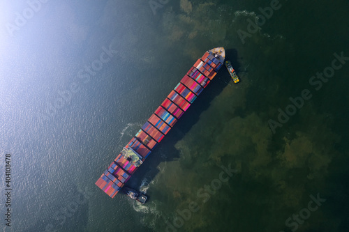 Container , container ship in export and import business and logistics. Shipping cargo to harbor by crane. Water transport International. Aerial view and top view. © MAGNIFIER