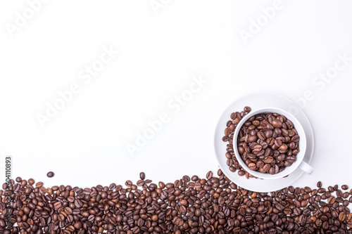 top view of White cup filled with freshly roasted coffee beans