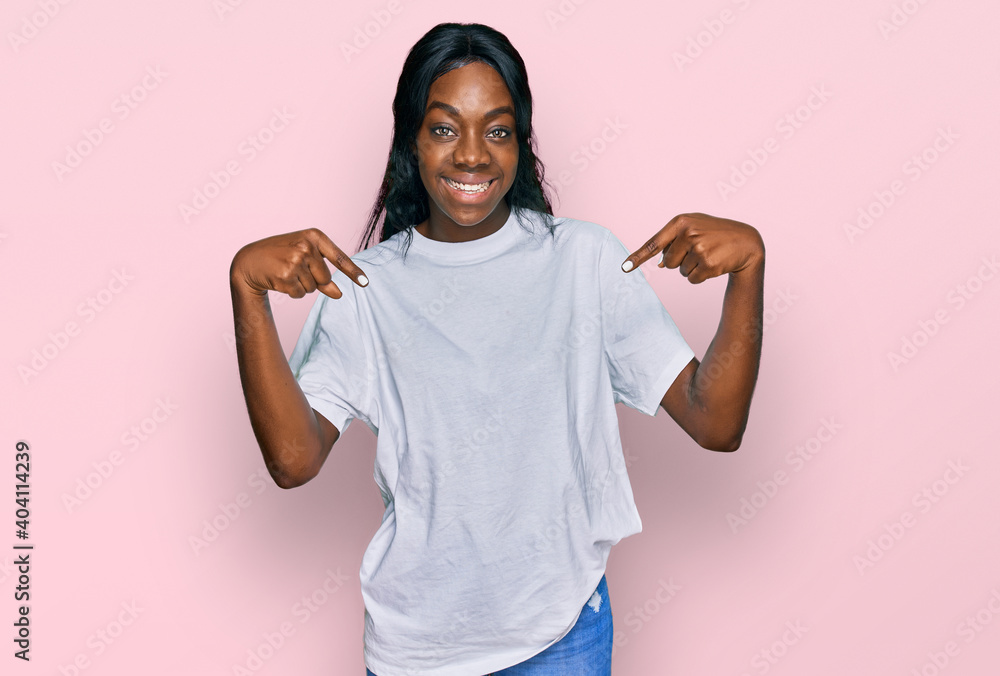 Young african american woman wearing casual white t shirt looking confident with smile on face, pointing oneself with fingers proud and happy. Young african american woman wearing casual white t shirt looking confident with smile on face, pointing oneself with fingers proud and happy.